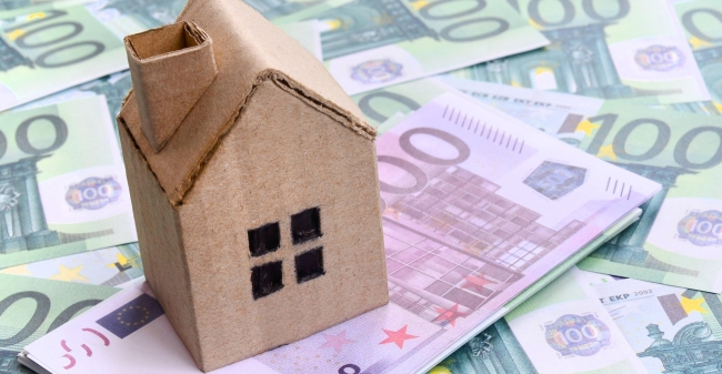 Small toy house is lies on a set of green monetary 2023 11 27 05 26 53 utc min