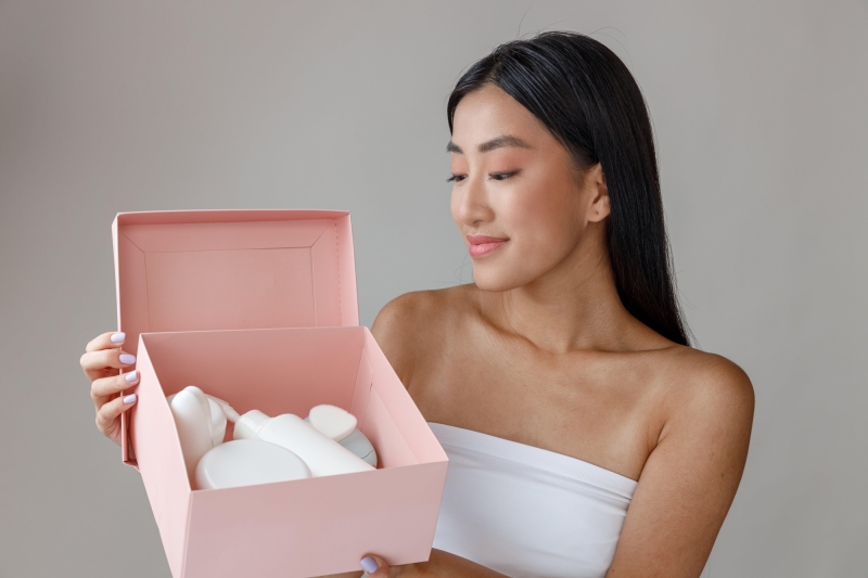 Smiling young woman holding box with cosmetic prod 2023 11 27 05 28 13 utc min